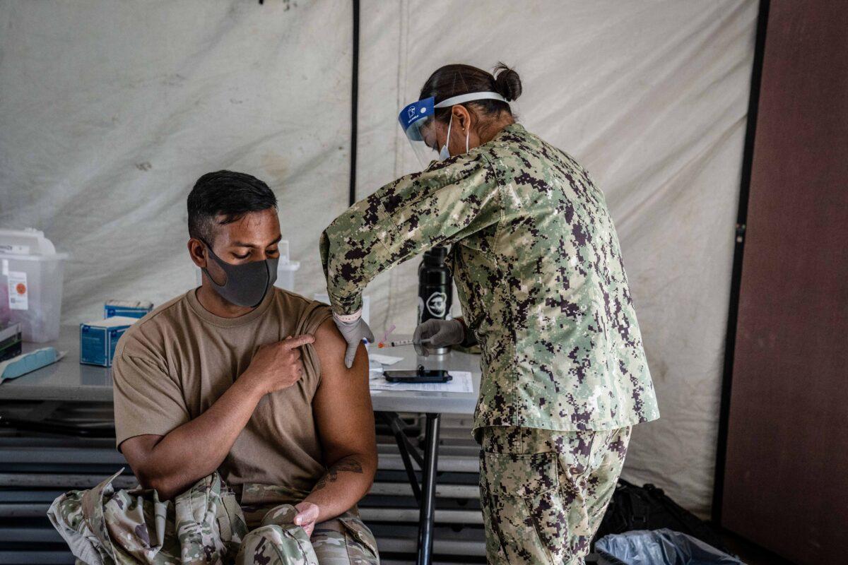 Ron DeSantis says if he's elected president he'll restore service members who were ejected from the military because of their vaccination status. Here, a member of the U.S. military receives the Moderna COVID-19 vaccine at Camp Foster in Ginowan, Japan, on April 28, 2021. (Carl Court/Getty Images)