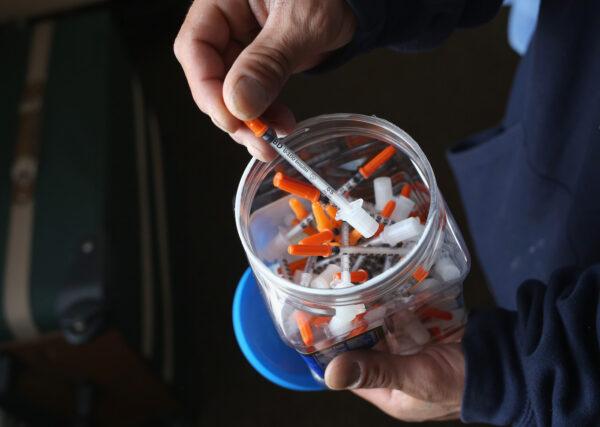 A drug user takes a needle before injecting himself with heroin in New London, Conn., on March 23, 2016. (John Moore/Getty Images)