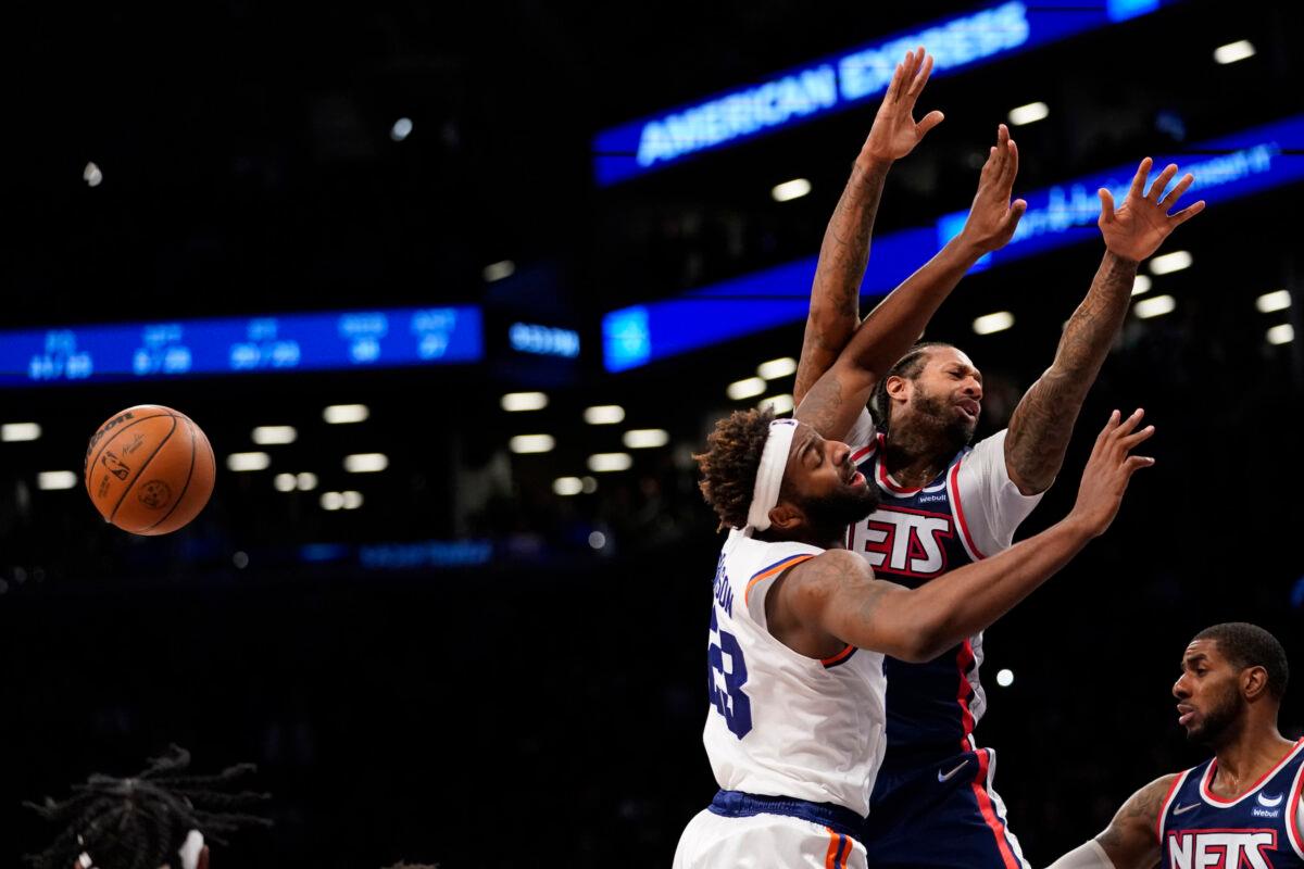 New York Knicks center Mitchell Robinson (23) fouls Brooklyn Nets forward James Johnson in the final seconds of the second half of an NBA basketball game, in New York, on Nov. 30, 2021. (Mary Altaffer/AP Photo)