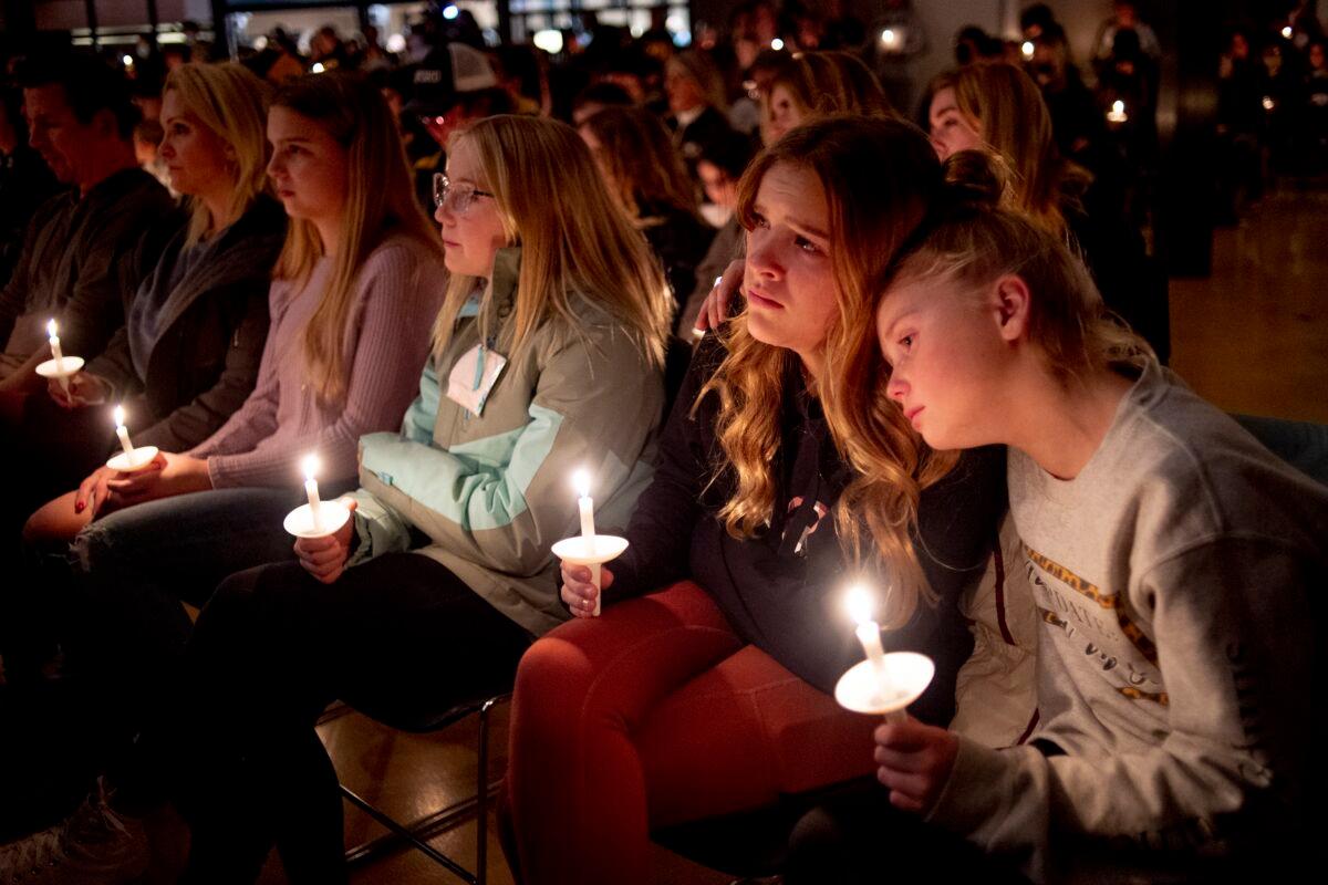 Emerson Miller, right, leans on her friend Joselyn's shoulder as they listen to Jessi Holt, pastor at LakePoint Community Church, during a prayer vigil at the church after the Oxford High School school shooting in Oxford, Mich., on Nov. 30, 2021. (Jake May/The Flint Journal via AP)