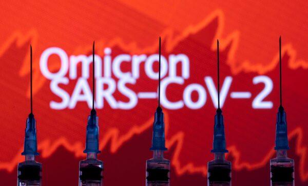 Syringes with needles are seen in front of a displayed stock graph and words "Omicron SARS-CoV-2" in this illustration taken on Nov. 27, 2021. (Dado Ruvic/Illustration/Reuters)
