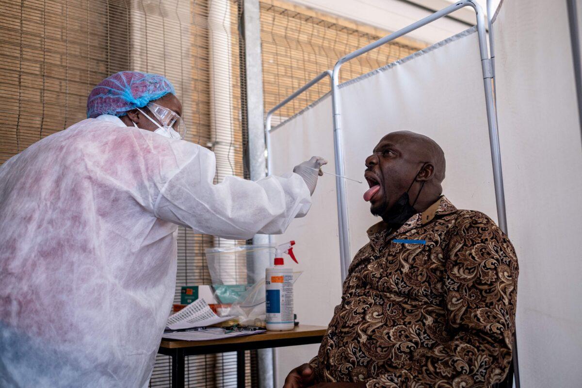 A health care worker conducts a COVID-19 test at the Lancet Laboratory in Johannesburg, on Nov. 30, 2021. (Emmanuel Croset/AFP via Getty Images)