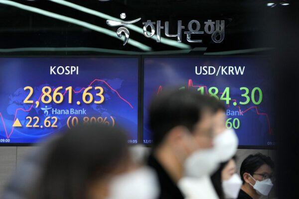 Currency traders watch computer monitors near the screens showing the Korea Composite Stock Price Index (KOSPI) (L) and the foreign exchange rate between U.S. dollar and South Korean won at a foreign exchange dealing room in Seoul, South Korea, on Dec. 1, 2021. (Lee Jin-man/AP Photo)