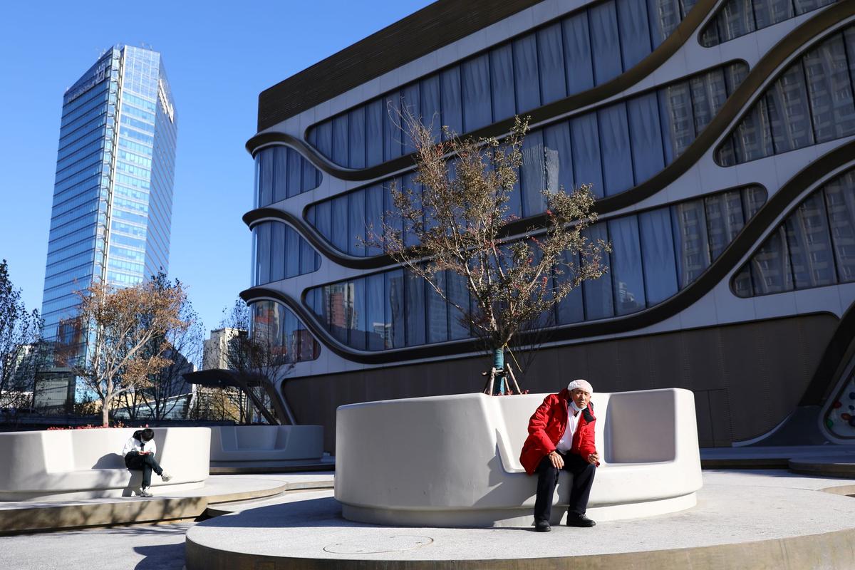 A man rests in front of a shopping mall at Kaisa Plaza, a property developed by Kaisa Group Holdings, in Beijing, China, on Dec. 1, 2021. (Tingshu Wang/Reuters)