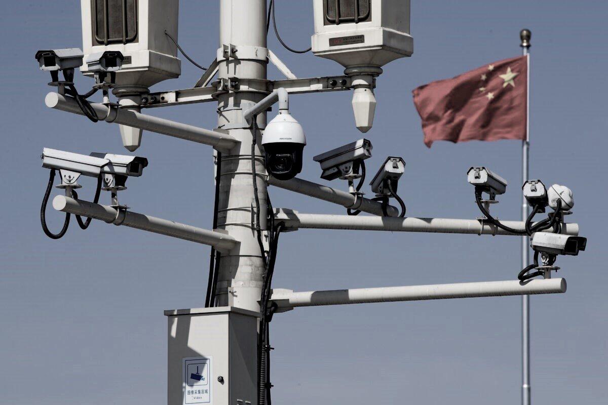 A Chinese national flag flutters near the surveillance cameras mounted on a lamp post in Tiananmen Square in Beijing, on March 15, 2019. (Andy Wong/AP Photo)
