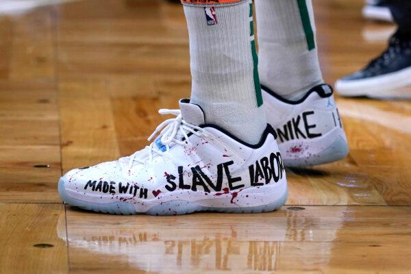 Enes Kanter Freedom wears basketball shoes bearing his political message during the first half of an NBA basketball game, in Boston, on Dec. 1, 2021. (Charles Krupa/AP Photo)