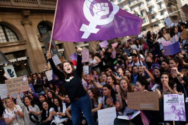 A woman waves a feminist flag as student protesters shout slogans during a demonstration marking International Women's Day in Barcelona, Spain, on March 8, 2019. (Pau Barrena/AFP via Getty Images)