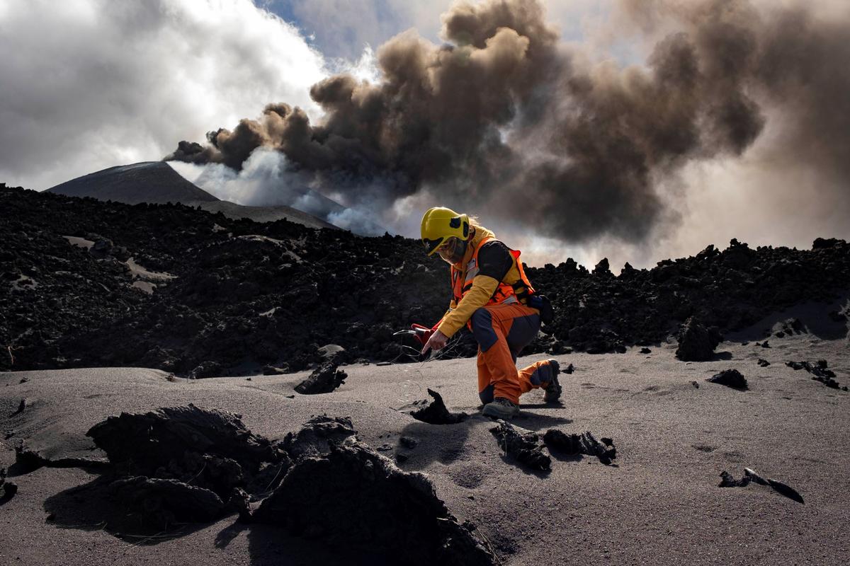 A scientist from IGME-CSIC (Geological and Mining Institute of Spain from Spanish National Research Council) measures the temperature of lava near a volcano on the Canary island of La Palma, Spain, on Nov. 5, 2021. (Taner Orribo/AP Photo)