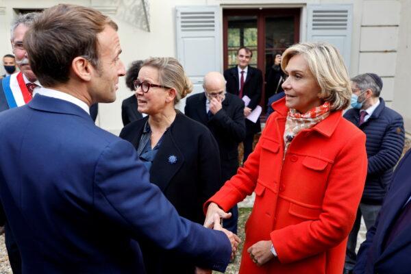 French President Emmanuel Macron greets Ile de France regional president and candidate for the French right-wing Les Republicains primary election Valerie Pecresse at the Emile Zola house in Medan, near Paris, on Oct. 26, 2021. (Ludovic Marin/Pool via Reuters)