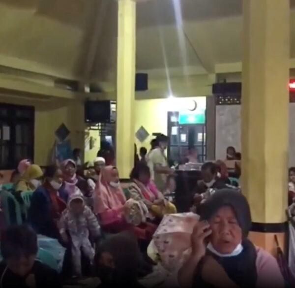 People wait at an evacuation center in Candipuro following the eruption of Indonesia's Semeru volcano, Lumajang, East Java Province, Indonesia December 4, 2021 in this screen grab obtained from a social media video. (Instagram @act_pasuruan/via Reuters)