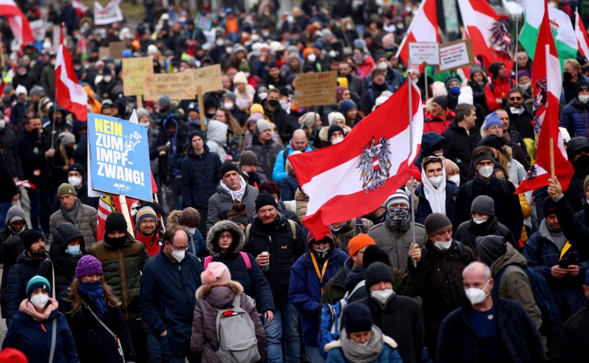Demonstrators hold flags and placards as they march to protest against COVID-19 restrictions and the mandatory vaccination in Vienna, Austria, on Dec. 4, 2021. (Lisi Niesner/Reuters)