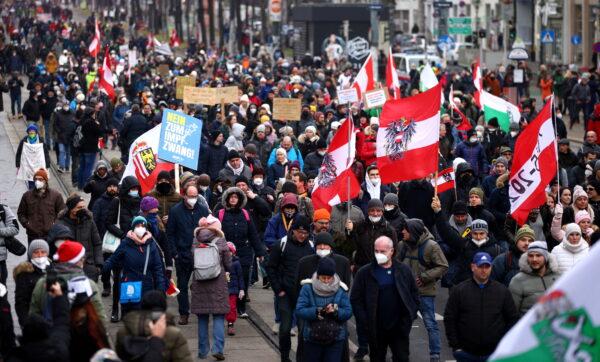 Demonstrators hold flags and placards as they march to protest against the coronavirus disease (COVID-19) restrictions and the mandatory vaccination in Vienna, Austria, on Dec. 4, 2021. (Lisi Niesner/Reuters)