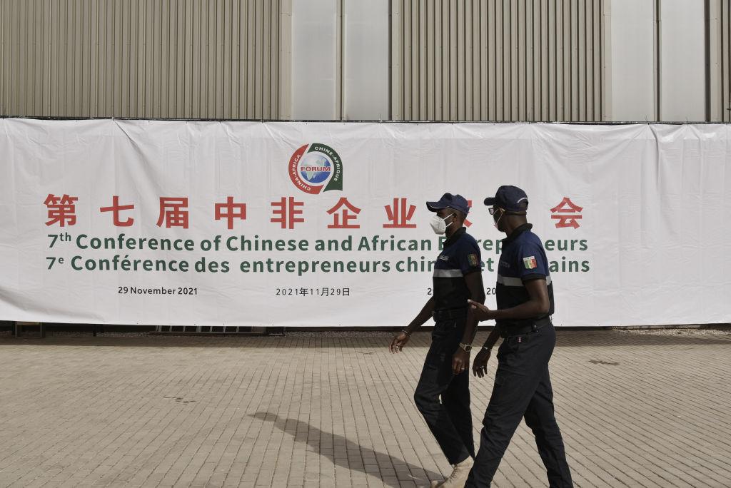 Security officers walk past a banner at the entrance of a conference hall during the China-Africa Cooperation (FOCAC) meeting at the Diamniadio in Dakar, Senegal, on Nov. 29, 2021. (Seyllou/AFP via Getty Images)