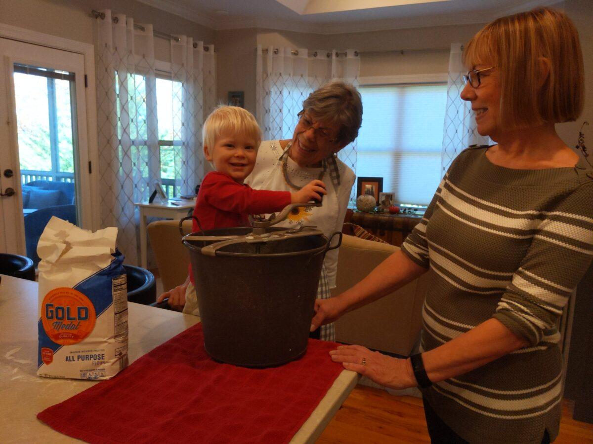 Blaise, the author's grandson, turns the crank of Nicoline's Universal Bread Maker—the sixth generation to do so. (Courtesy of Doris Richardson)