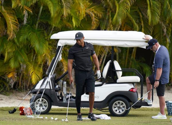 Tiger Woods (L) sets a ball during a practice session at the Albany Golf Club in New Providence, Bahamas, on Dec. 4, 2021. (Fernando Llano/AP Photo)
