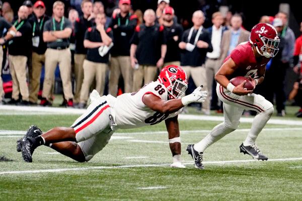 Alabama quarterback Bryce Young (9) runs past Georgia defensive lineman Jalen Carter (88) for a touchdown during the first half of the Southeastern Conference championship NCAA college football game, in Atlanta on Dec. 4, 2021. (Brynn Anderson/AP Photo)