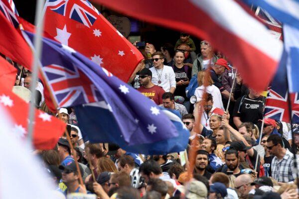 Protesters hold flags during a rally against new pandemic laws and vaccination mandates in Melbourne, Australia, on Dec. 4, 2021. (William WestT/AFP via Getty Images)