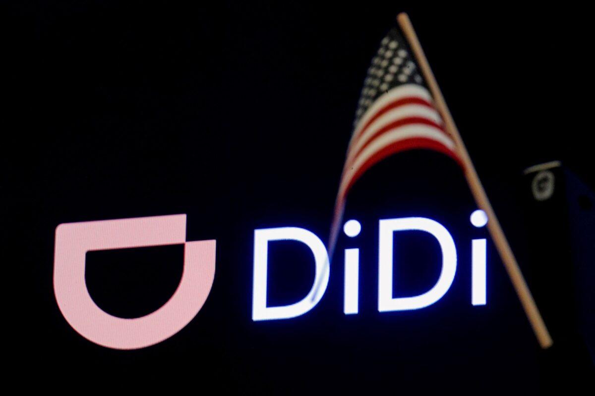 An American flag is pictured in front of the logo for Chinese ride-hailing company Didi Global Inc. during the IPO on the New York Stock Exchange (NYSE) floor in New York on June 30, 2021. (Brendan McDermid/Reuters)