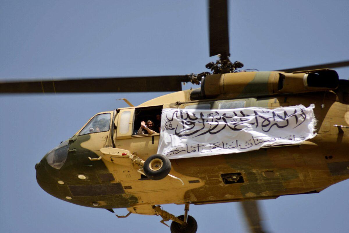 A helicopter flies a Taliban flag to celebrate the United States' withdrawal of its troops from Afghanistan, in Kandahar, Afghanistan, on Sept. 1, 2021. Critics have lambasted Biden's manner of withdrawal as one of the worst military debacles in U.S. history. (JAVED TANVEER/AFP via Getty Images)