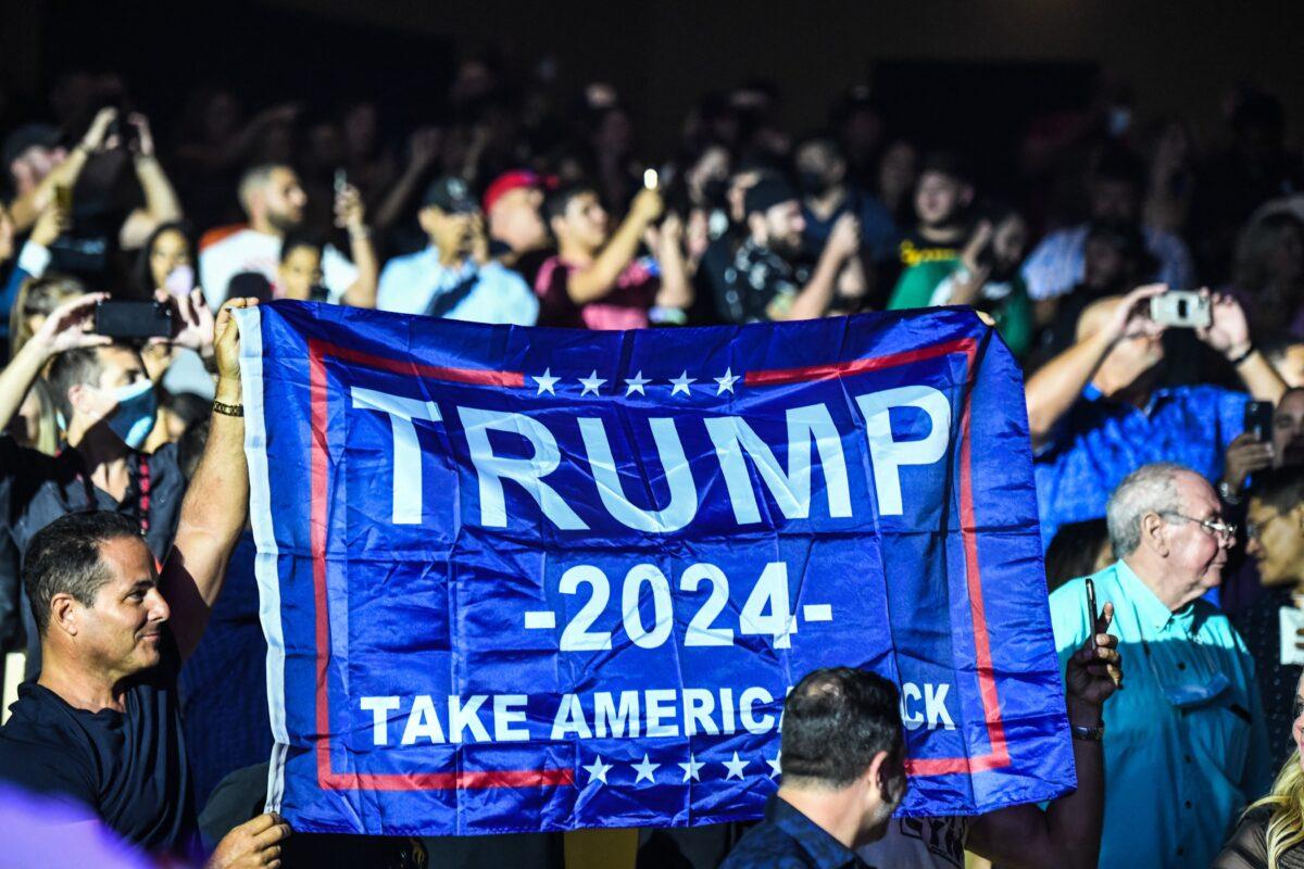 Supporters of former President Donald Trump hold a flag reading "Trump 2024 as he hosts the Holyfield versus Belford boxing match live with commentary at the Hard Rock Live in Hollywood, Fla., on Sept. 11, 2021. (CHANDAN KHANNA/AFP via Getty Images)