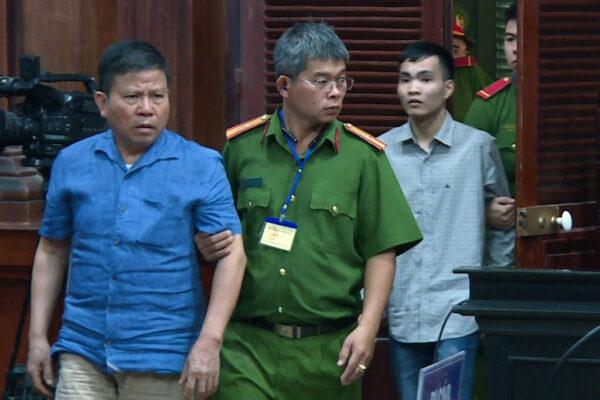 This picture from the Vietnam News Agency, taken and released on November 11, 2019, shows Australian citizen Chau Van Kham (L) escorted for trial in Ho Chi Minh City. (Vietnam News Agency/AFP via Getty Images)