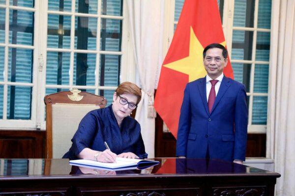 Australia's Foreign Minister Marise Payne (L) signs a guestbook next to her Vietnamese counterpart Bui Thanh Son (R) at the Government Guest House in Hanoi on November 9, 2021. (LUONG THAI LINH / POOL / AFP)