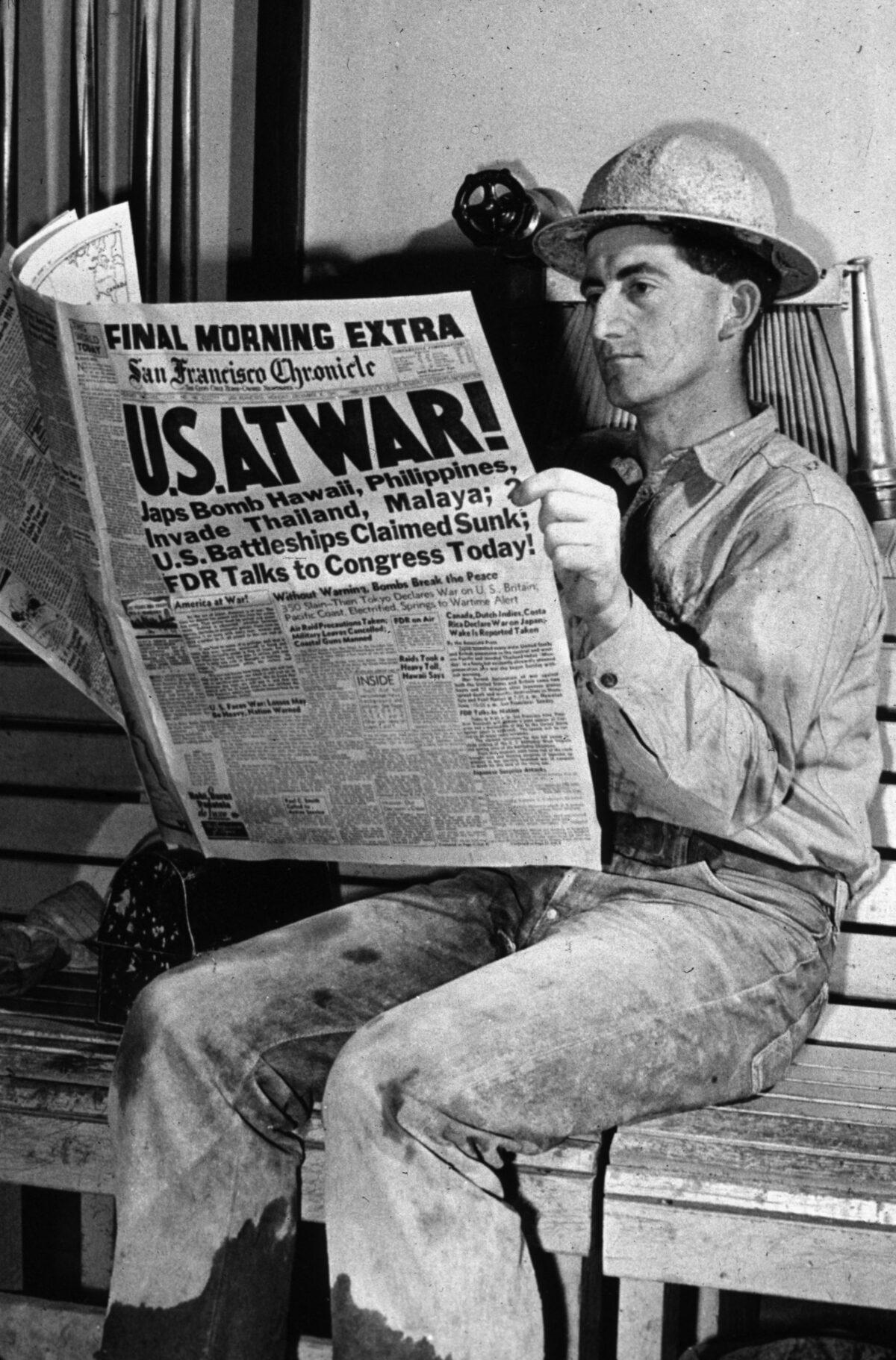 A man reading an account of the bombing of Pearl Harbor in the San Francisco Chronicle at the Shasta Dam in California. (Russell Lee/Library Of Congress/Getty Images)