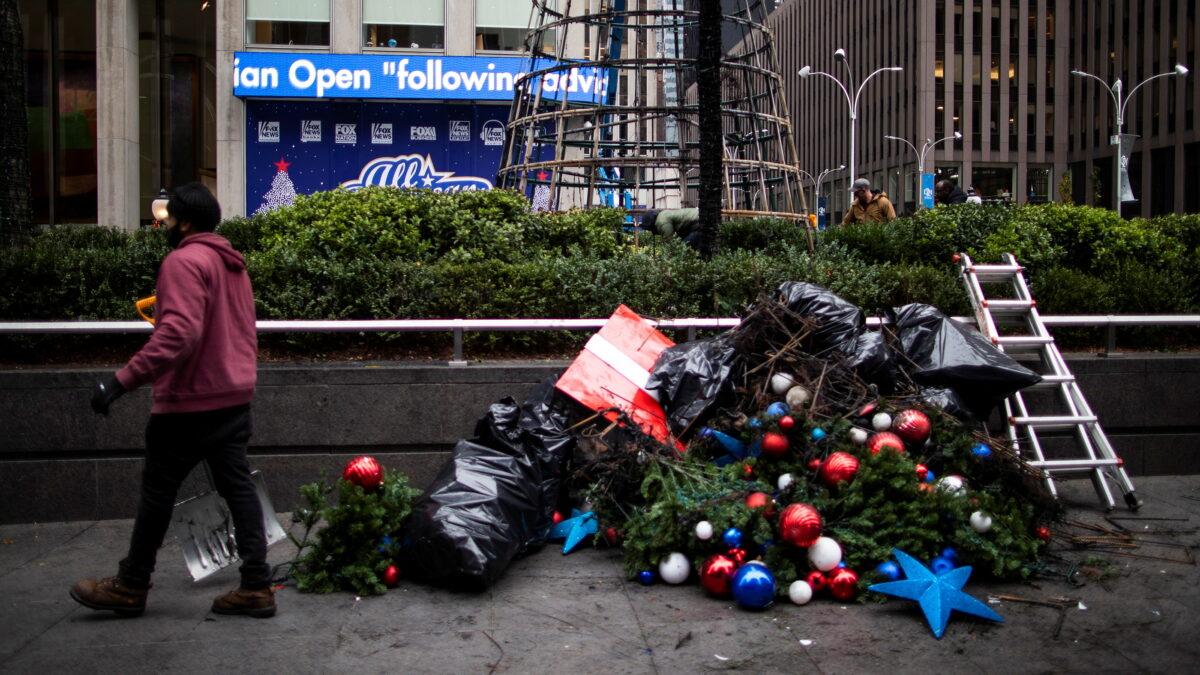 Christmas decorations are seen on the floor as workers clean up the burnt remains of a Christmas tree outside the News Corporation and Fox News building in N.Y.C., on Dec. 8, 2021. (Eduardo Munoz/Reuters)