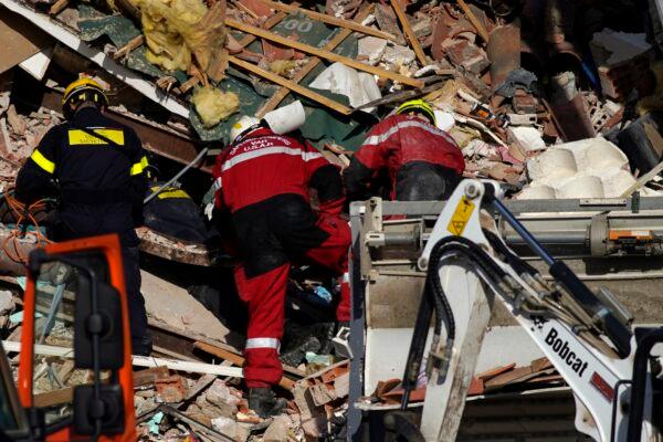 Rescue workers search the rubbles at a three-story apartment building after it collapsed in a suspected gas explosion on southern France's Mediterranean coast in Sanary-sur-Mer, on Dec. 7, 2021. (Daniel Cole/AP Photo)