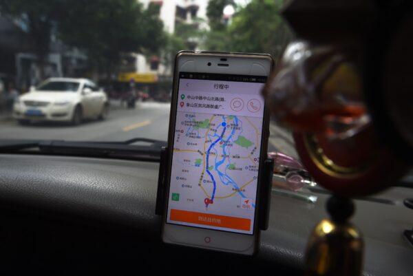 A taxi driver uses the Didi Chuxing app while driving along a street in Guilin, in China's southern Guangxi region on May 13, 2016. (GREG BAKER/AFP via Getty Images)