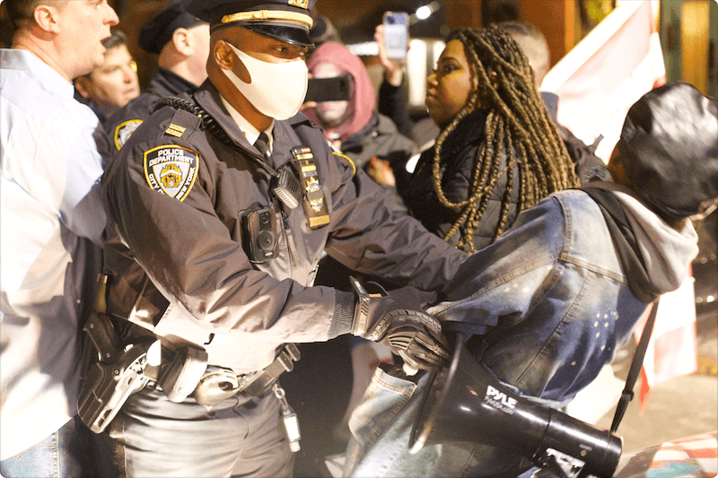 Police getting protesters out of the roadway outside Bill de Blasio's residence in Brooklyn, New York, on Dec. 8, 2021. (Enrico Trigoso/The Epoch Times)