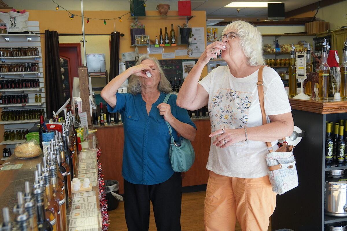 Sharon Fultd, from Indiana, and her friend Ellen Hollingsworth, from Punta Gorda, sample the products at Bella Balsamic in Punta Gorda, Fla, on Dec. 7, 2021. (Jann Falkenstern/The Epoch Times)