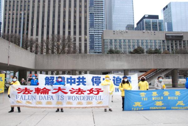 Falun Gong adherents hold banners at a rally outside Toronto City Hall on Dec. 7, 2021, calling on the federal government to pressure the Chinese Communist Party to end the persecution of Falun Gong. (Michelle Hu/The Epoch Times)