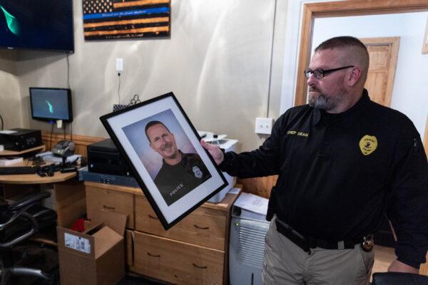 Stanley Police Chief Ryan Dean holds an illustration of Stanley Police Officer Dominic “Nick” J. Winum, in Luray., Va., on Dec. 1, 2021. (Graeme Jennings for The Epoch Times)