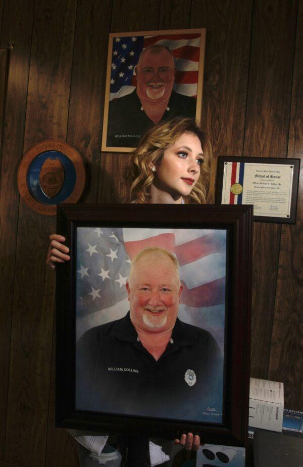 Danielle Collins, daughter of slain police officer William "Billy" Collins poses with a portrait of her father, in Doyline, La., on Nov. 17, 2021. (Bobby Sanchez for The Epoch Times)