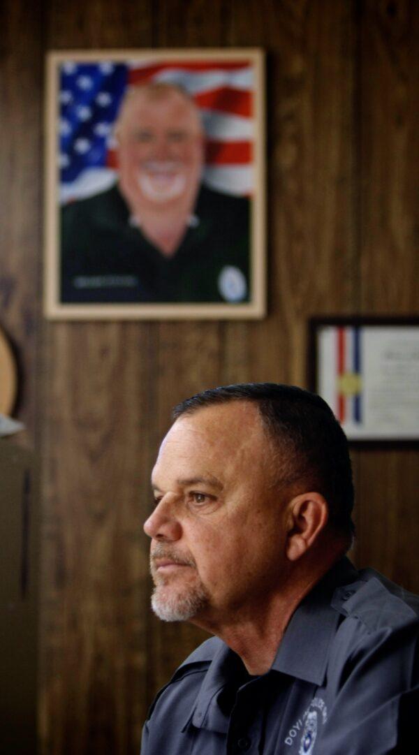 Under a portrait of William "Billy" Collins, Doyline Police Chief Robert Hayden remembers the day officer Collins was shot, in Doyline, La., on Nov. 17, 2021. (Bobby Sanchez for The Epoch Times)