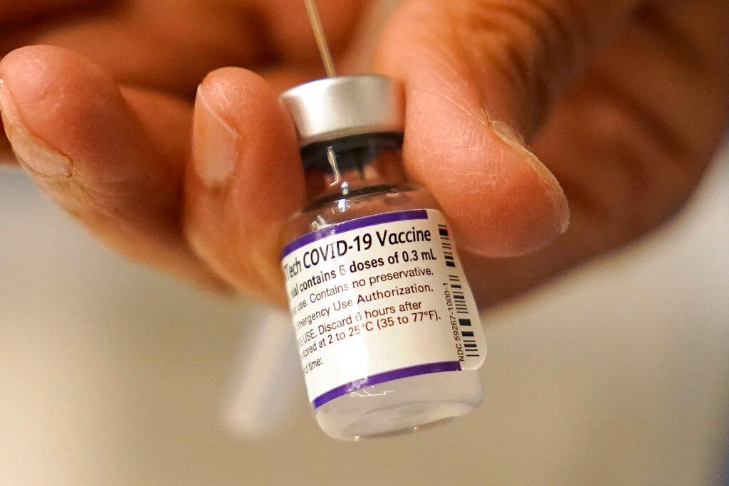 A Pfizer COVID-19 vaccine was transferred into a syringe at a mobile vaccination clinic in Worcester, Mass., on Dec. 2, 2021. (Steven Senne/AP Photo)