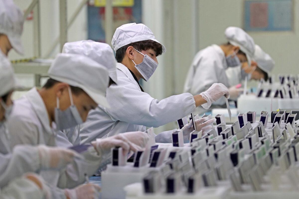 Workers at a production line manufacturing solar photovoltaic components at a factory in Zhejiang Province, China, on Feb. 12, 2019. (Lin Yunlong/Zhejiang Daily via Reuters)