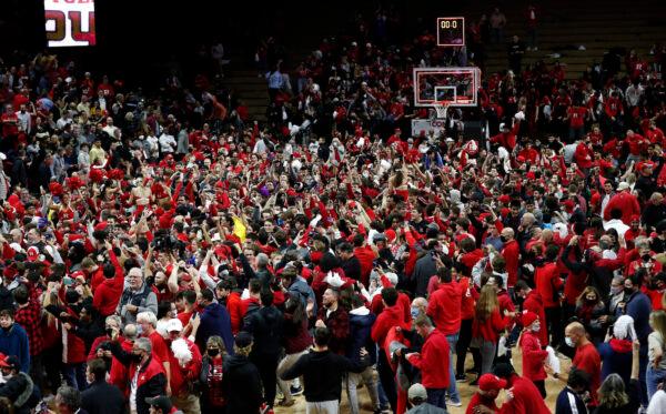 Fans run on the court after Rutgers defeated Purdue 70–68 during an NCAA college basketball game in Piscataway, N.J., on Dec. 9, 2021. (Noah K. Murray/AP Photo)