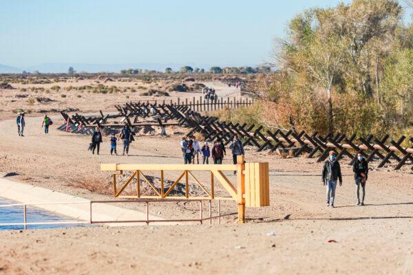 Illegal immigrants walk toward the border fence to wait for Border Patrol after crossing from Mexico into the United States in Yuma, Arizona, on Dec. 10 2021. (Charlotte Cuthbertson/The Epoch Times)