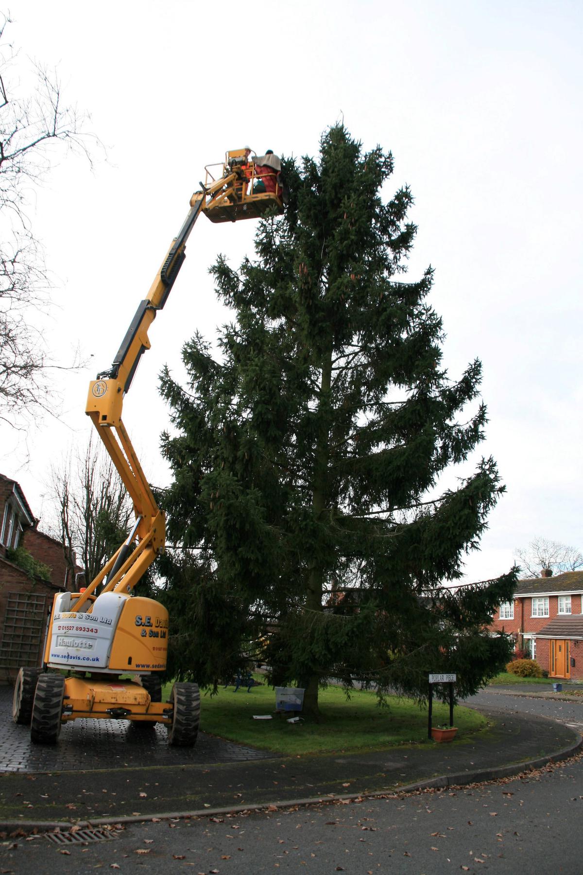 Avril and Christopher Rowlands from Inkberrow in Worcestershire decorate their giant Christmas tree using a cherry picker in 2013. (SWNS)