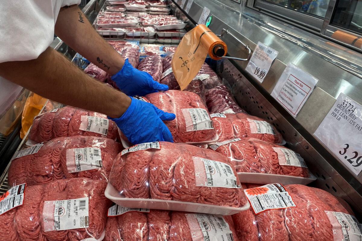 A worker stacks packets of ground beef in the meat section of a Costco warehouse club in Webster, Texas, on May 5, 2020. (Adrees Latif/Reuters)