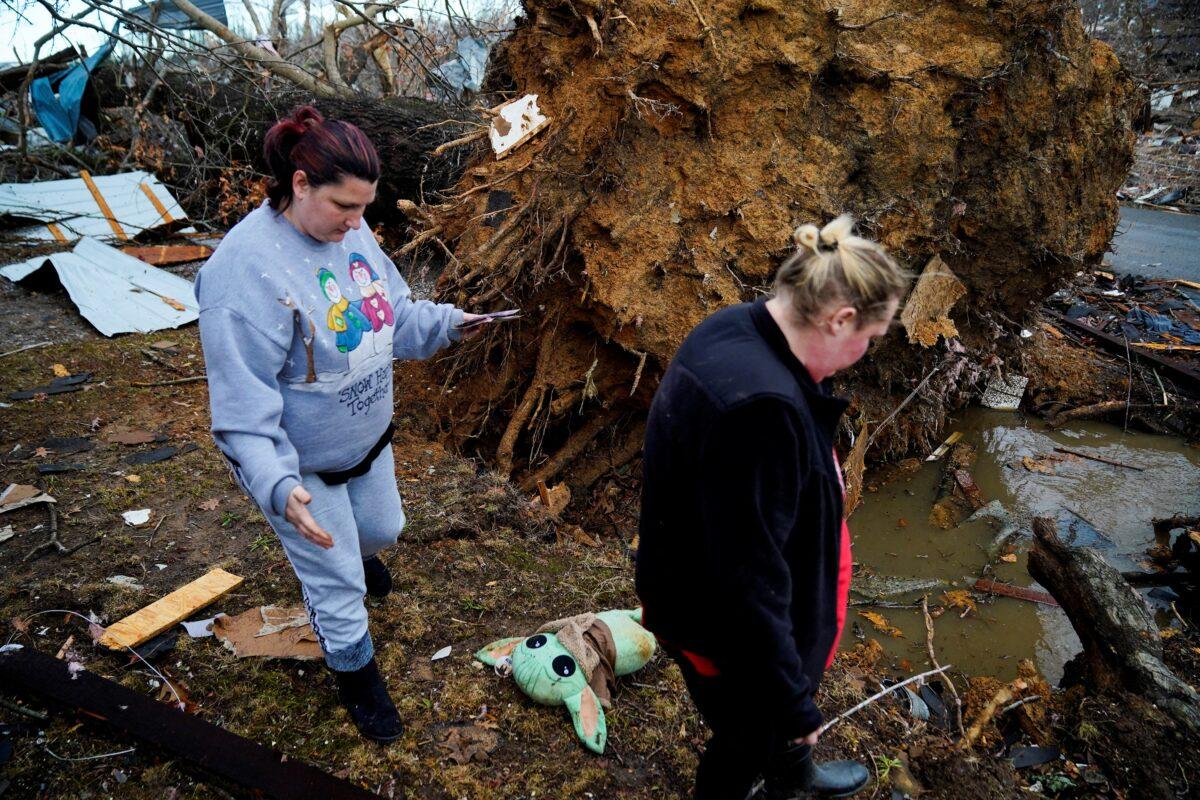 Amy Meno and Brooklyn Rogers search for belongings after a devastating outbreak of tornadoes ripped through several U.S. states in Earlington, Ky., on Dec. 11, 2021. (Cheney Orr/Reuters)