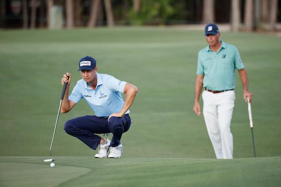 NAPLES, FLORIDA - DECEMBER 10: Harris English of the United States lines up a putt as Matt Kuchar of the United States looks on on the 17th green during the first round of the QBE Shootout at Tiburon Golf Club in Naples, Florida, on December 10, 2021. (Cliff Hawkins/Getty Images)