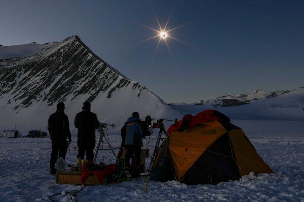 Chilean and U.S. scientists looking at a solar eclipse from the Union Glacier in Antarctica, on Dec. 4, 2021. (FELIPE TRUEBA/Imagen Chile/AFP via Getty Images)