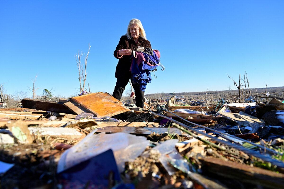Laura Croft searches through debris near the location where her mother and aunt were found deceased after tornadoes ripped through several U.S. states in downtown Dawson Springs, Ky., on Dec. 13, 2021. (Jon Cherry/Reuters)