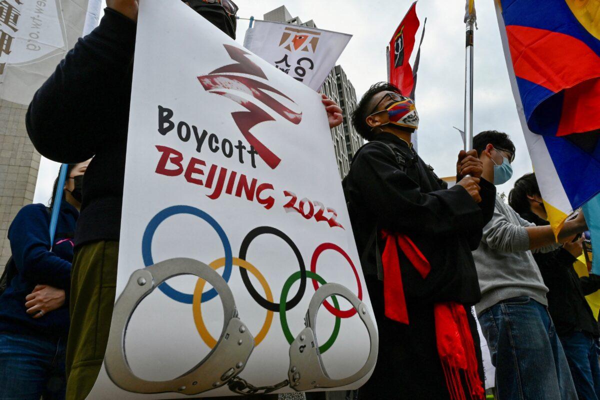 Human rights activists hold banners as they protest in Taipei against the 2022 Beijing Olympic Games to mark Human Rights Day on Dec. 10, 2021. (Sam Yeh/AFP via Getty Images)