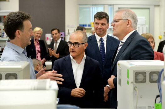 Australian Prime Minister Scott Morrison (R) and Victorian Deputy Premier James Merlino (C) tour The Peter Doherty Institute for Infection and Immunity in Melbourne, Australia with Dr Julian Druce, head of the Virus Identification Lab (M) on Dec. 14, 2021 (Andrew Henshaw/POOL/AFP via Getty Images)