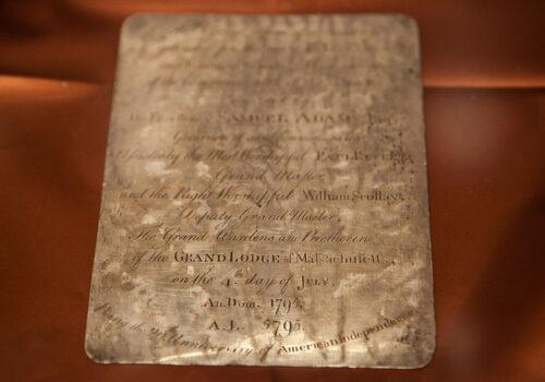 A silver plaque inscribed by Paul Revere, silver and copper coins, and newspapers were found in a 1795 time capsule placed under the State House cornerstone by Gov. Samuel Adams, Paul Revere, and Col. William Scollay. (Kayana Szymczak/Getty Images)