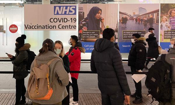 A queue of people waiting to receive their COVID-19 booster jab at an NHS vaccination center in London on Dec.14, 2021. (Leon Neal/Getty Images)